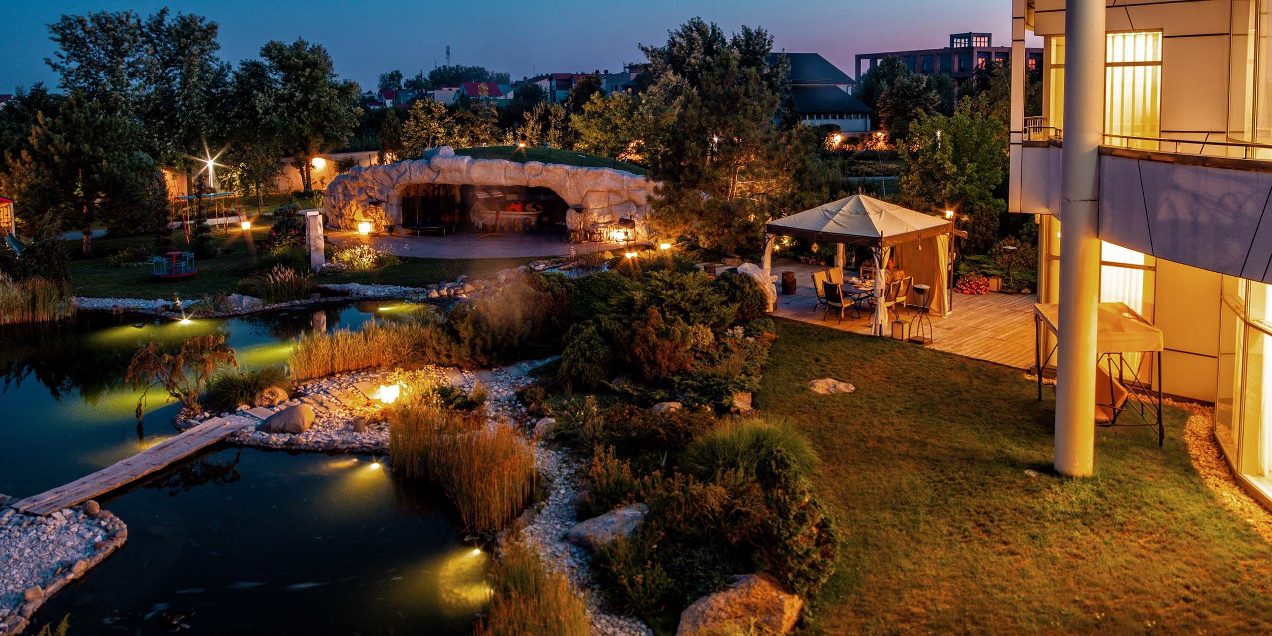 landscape overview image with river, lighting, and sitting areas at dusk