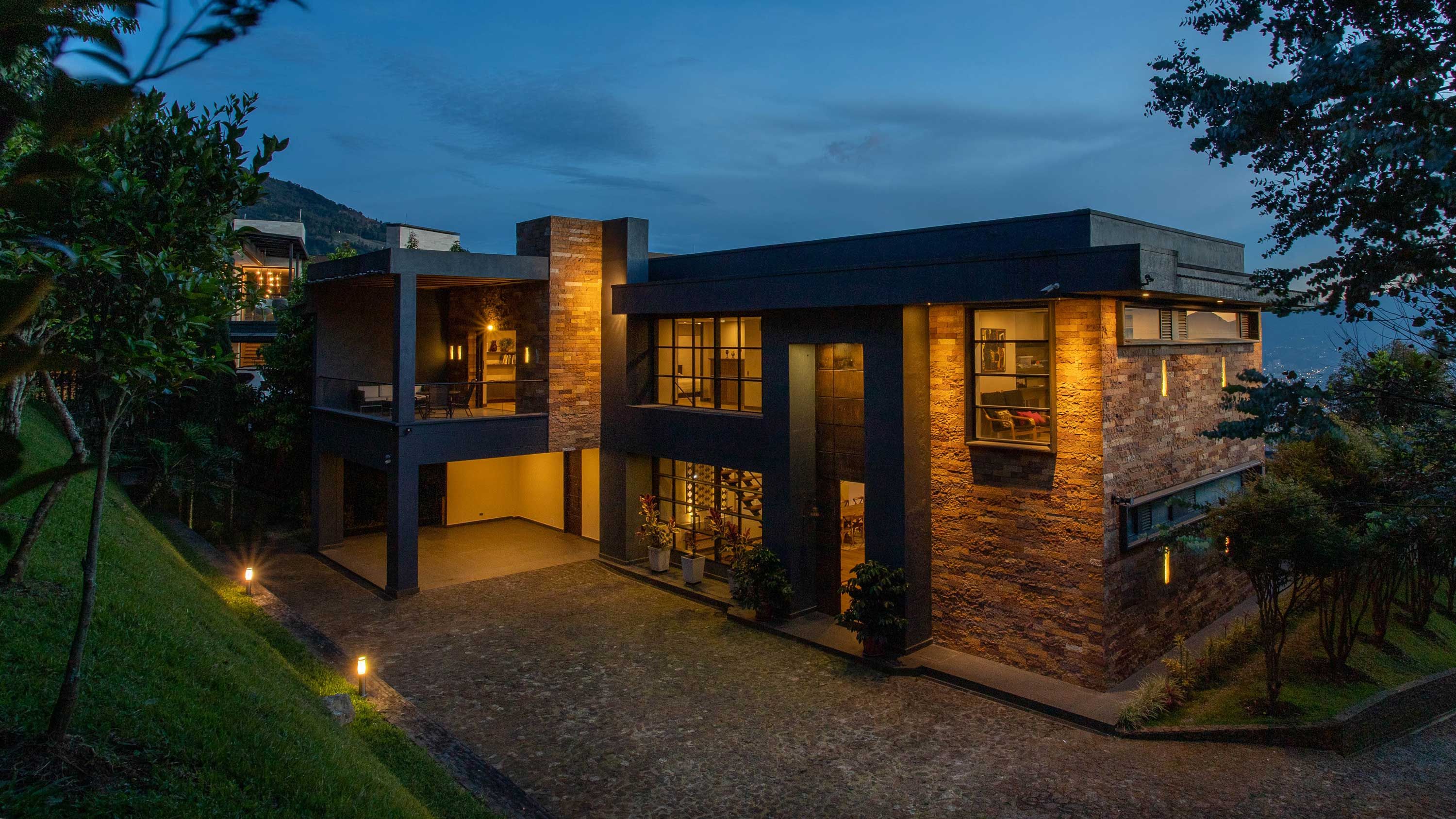 modern stone home with black accents at dusk