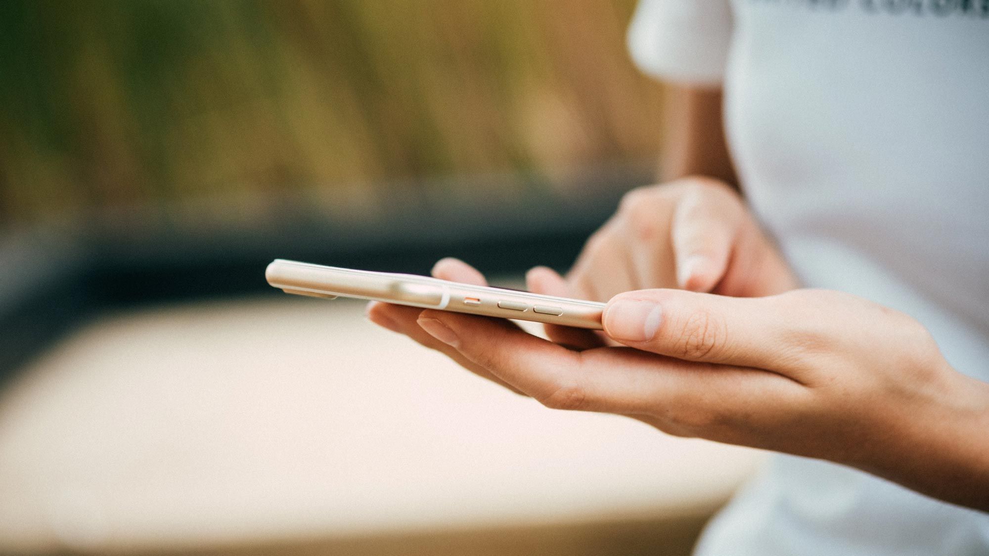 woman typing on gold phone